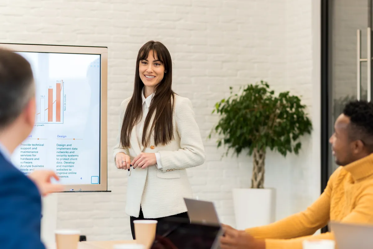 Strategist presenting a strategic plan to two business partners in a meeting room