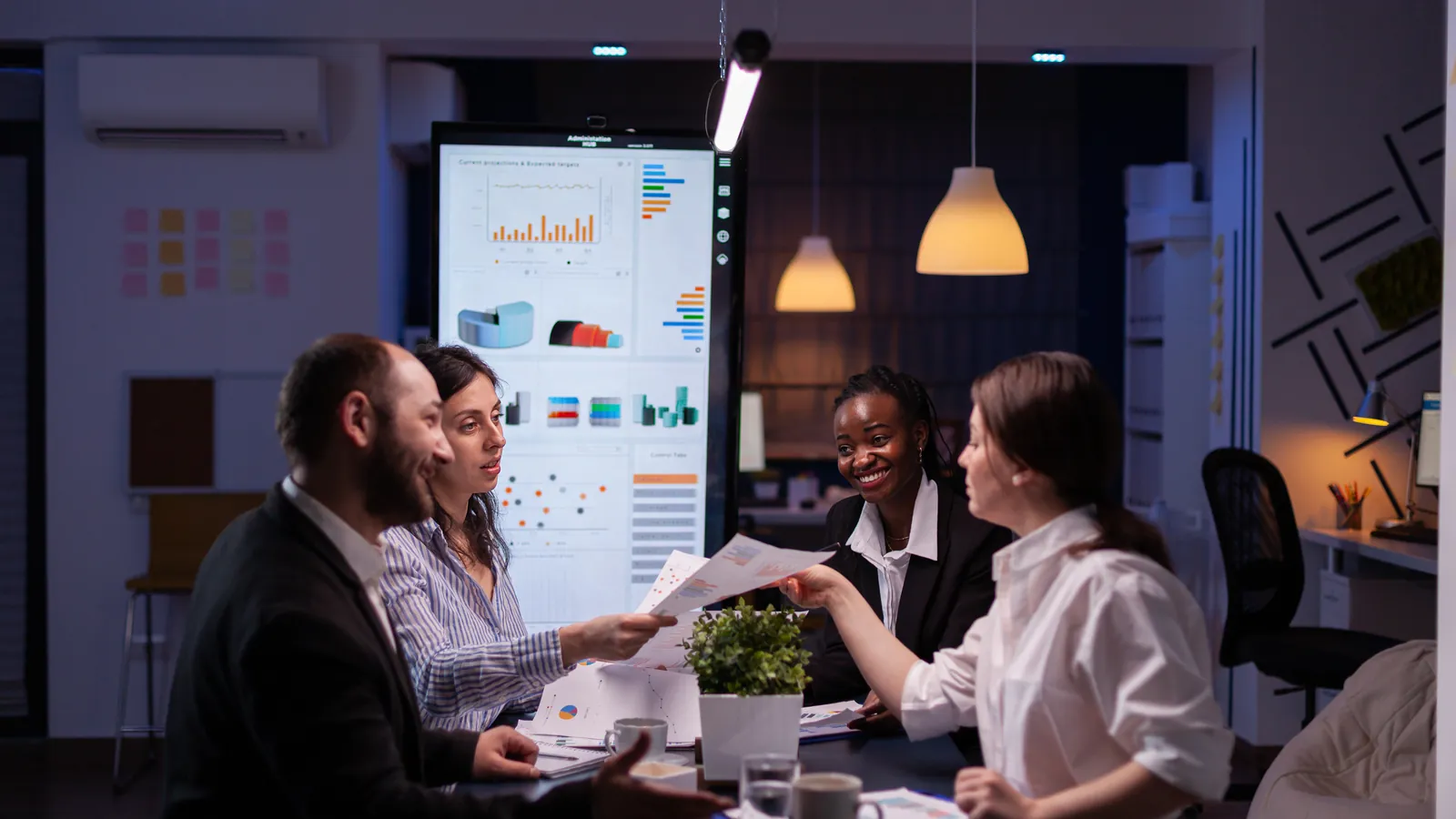 Team gathered around a table at night, discussing a company's marketing strategy