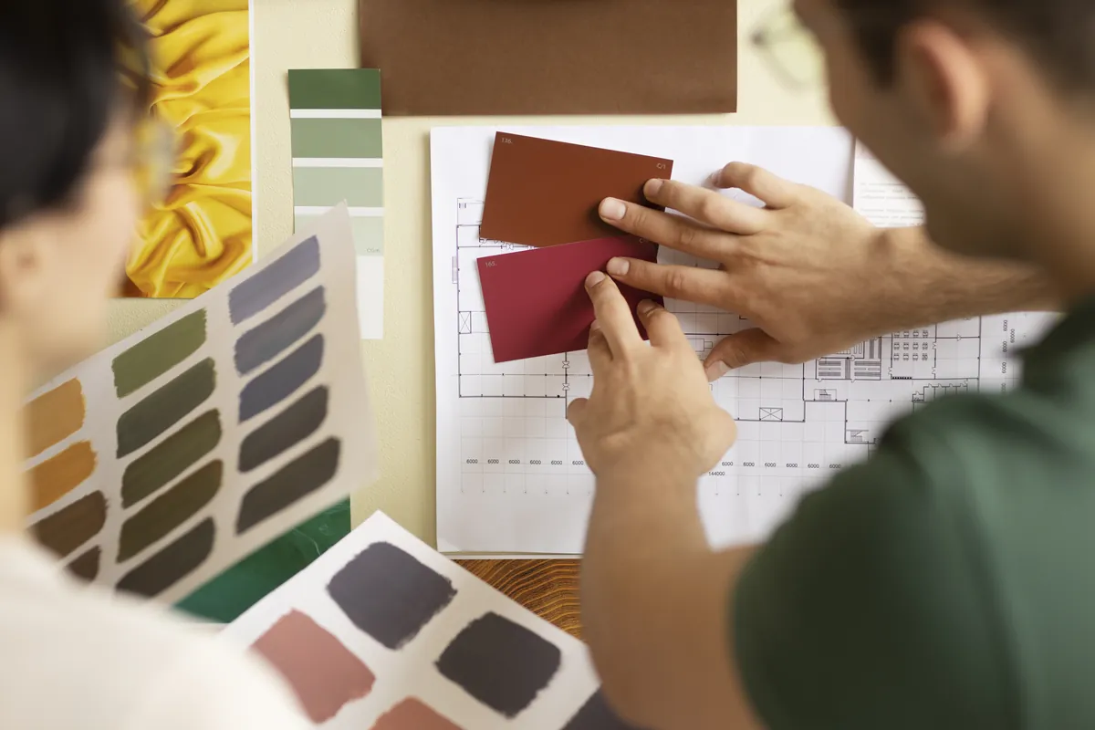 Manos eligiendo muestras de color sobre una mesa durante la creación de una identidad visual